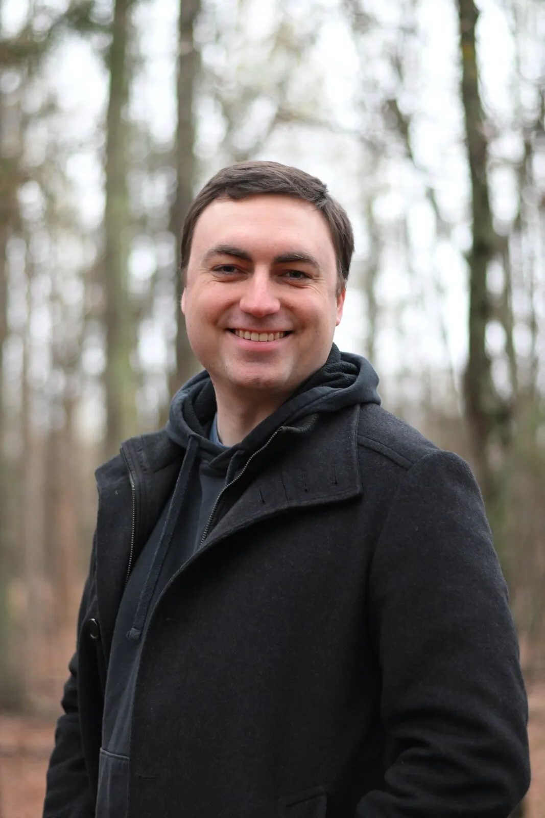Mike Loerop in a dark coat among bare winter trees